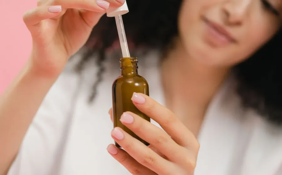 Wanita mengoleskan serum wajah untuk merawat kulit dengan manfaat retinol untuk wajah