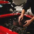 Mekanik sedang membersihkan filter udara kendaraan di bengkel otomotif