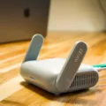 Perangkat router Mesh Wi-Fi putih terpasang rapi di atas meja ruang keluarga rumah luas