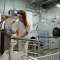 Tumpukan pakaian kotor dan mesin cuci bukaan depan untuk persiapan usaha laundry kiloan rumahan