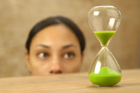 Ibu sedang menerapkan cara mengajarkan anak sabar menggunakan timer visual di meja makan