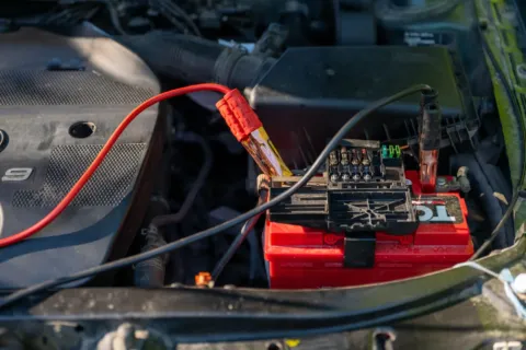 Teknisi mengecek tegangan aki saat perawatan sistem kelistrikan motor
