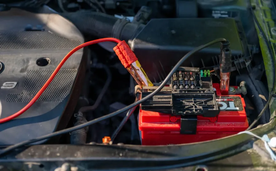 Teknisi mengecek tegangan aki saat perawatan sistem kelistrikan motor