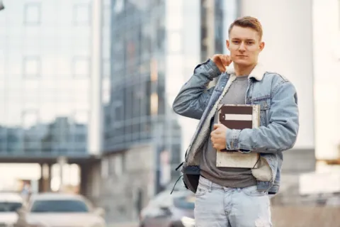 Gaya berpakaian ke kampus pria dan wanita dengan kemeja overshirt kasual dan sepatu sneakers