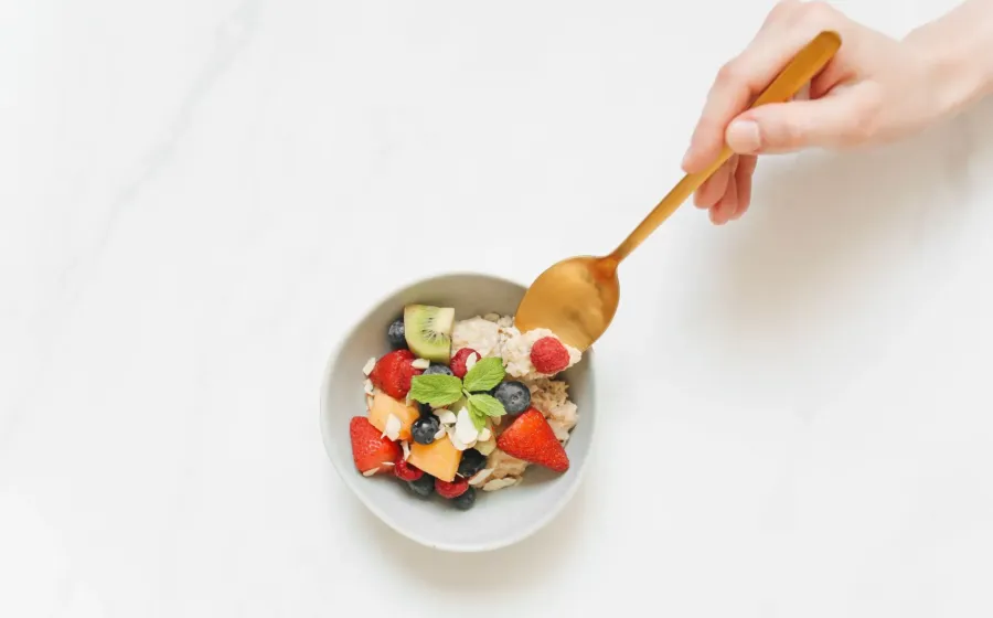 Menu kebiasaan sarapan sehat berisi oatmeal potongan pisang dan telur rebus di atas meja