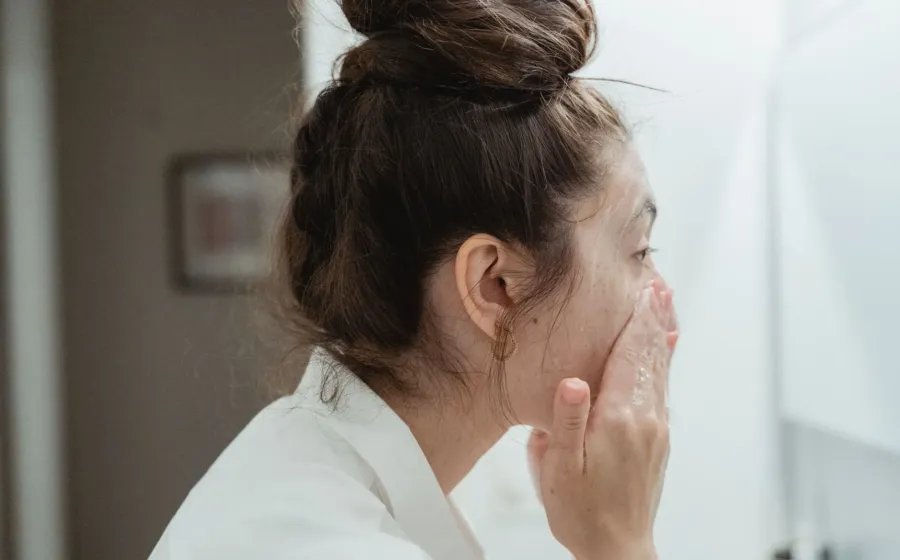 Seseorang sedang membasuh wajah dengan air mengalir untuk mendapatkan manfaat cuci muka yang benar