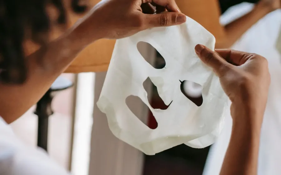 Seorang wanita menikmati manfaat sheet mask rutin untuk melembapkan kulit wajah