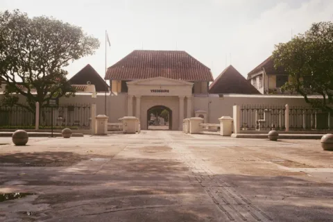 Suasana kompleks benteng bersejarah Vredeburg dengan halaman rumput dan bangunan tua di Yogyakarta