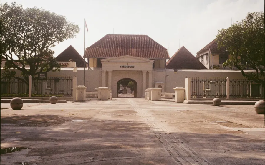 Suasana kompleks benteng bersejarah Vredeburg dengan halaman rumput dan bangunan tua di Yogyakarta