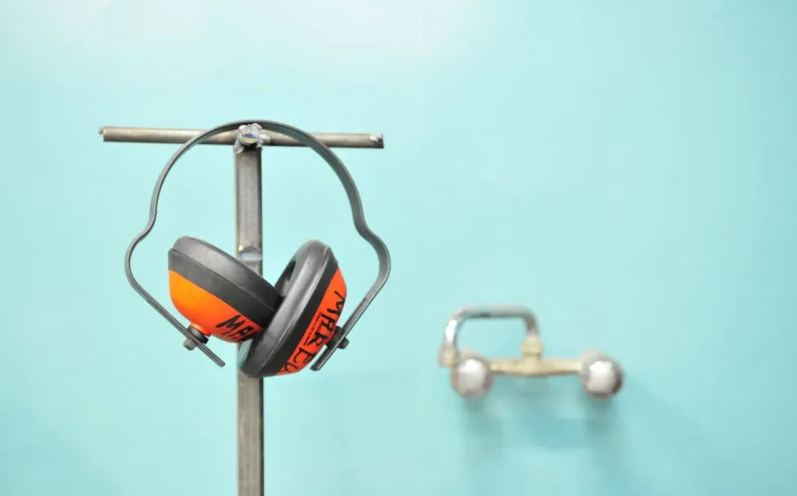 Seseorang sedang memakai rekomendasi headphone peredam bising saat bekerja fokus di depan laptop