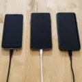 Kabel data awet nilon rajut warna hitam terhubung ke smartphone di atas meja kerja