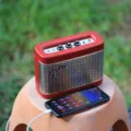 Rekomendasi speaker portable outdoor tahan air diletakkan di atas batu dekat area kemping