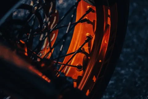 Seseorang sedang membersihkan velg motor agar bersih mengilap dengan kain microfiber